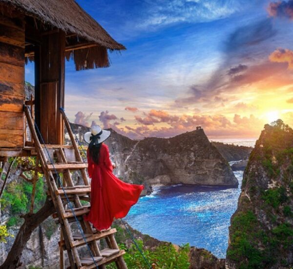 Woman embracing the sunrise in the mountains, symbolizing a new beginning after heartbreak