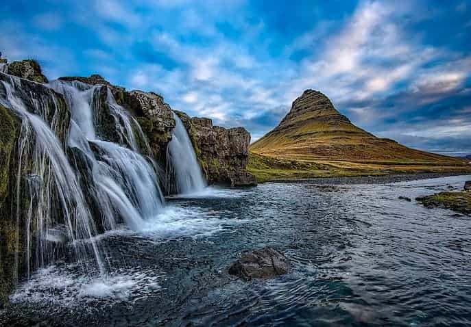 Scenic waterfall and mountain landscape in Iceland, one of the best places to travel after a breakup for emotional healing and clarity