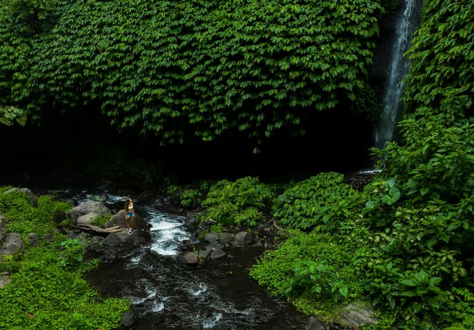 Woman hiking through lush rainforest in Costa Rica during a women-only adventure retreat focused on confidence building, nature therapy, and outdoor wellness experiences. 