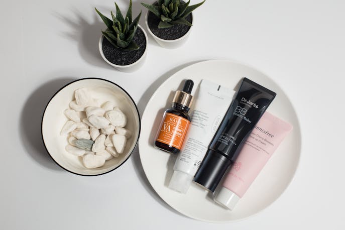 Gender-neutral skincare products on a white plate with natural decor