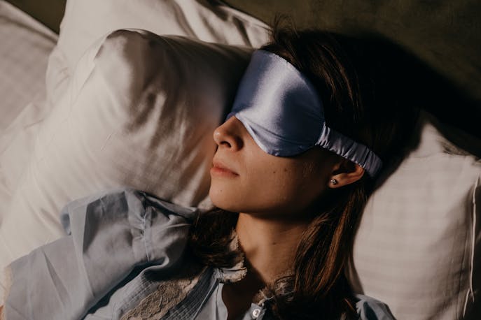 Woman sleeping peacefully with an eye mask during a long flight