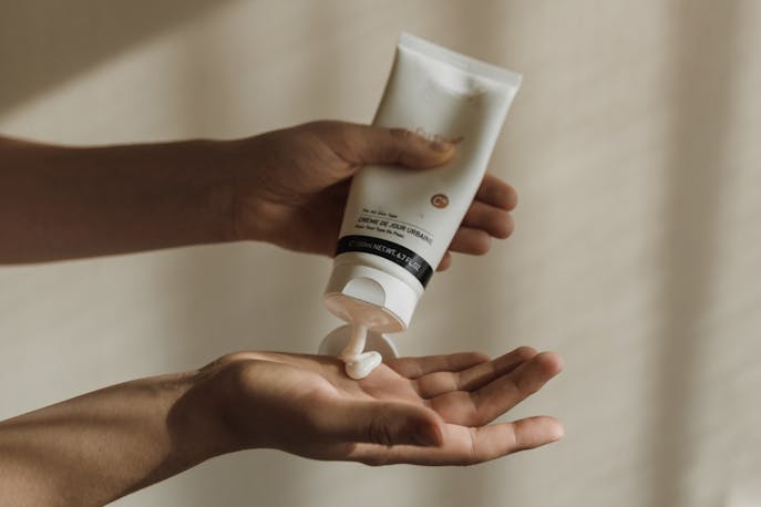 Applying cream from a tube to hand for in-flight skincare