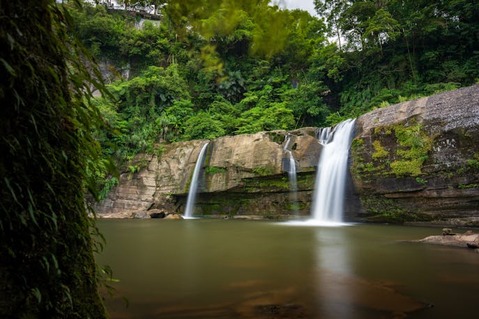 Serene double waterfalls flowing into a lush green jungle pool at Semuc Champey.