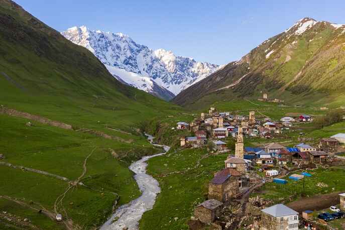 Remote village of Svaneti surrounded by snow-capped Caucasus mountains.