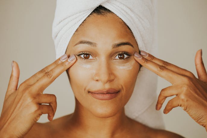 Woman applying under-eye cream for climate-specific skincare