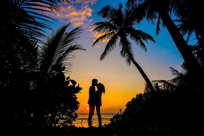 Romantic couple kissing during sunset on a scenic hilltop in India – romantic getaway ideas for couples.