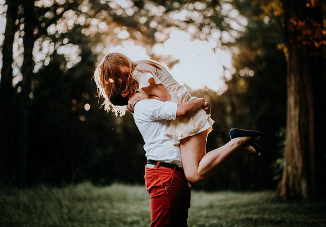 Romantic couple enjoying a playful moment in a forest during a mindful Valentine’s Day nature getaway
