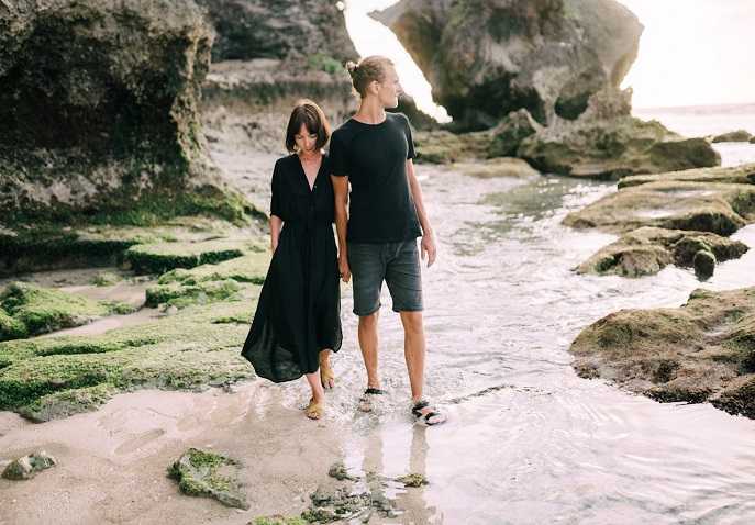 Couple walking along a rocky beach during a quiet Valentine’s Day coastal trip
