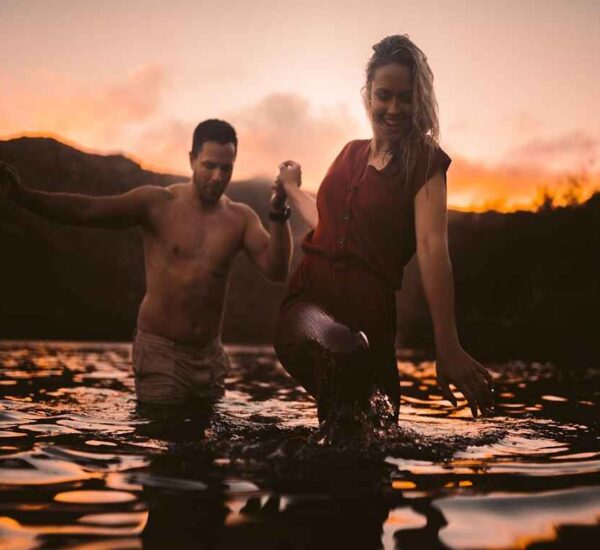 A couple, enjoying an evening in a lake surrounded by mountains