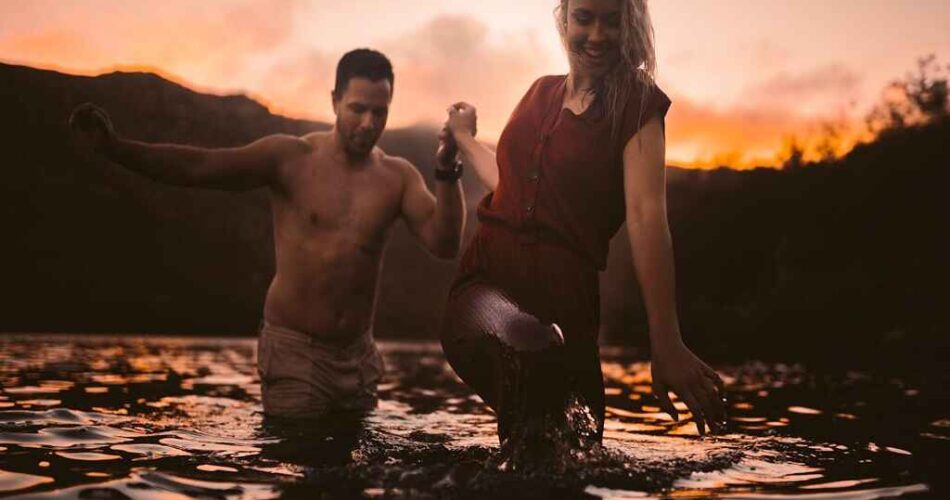 A couple, enjoying an evening in a lake surrounded by mountains