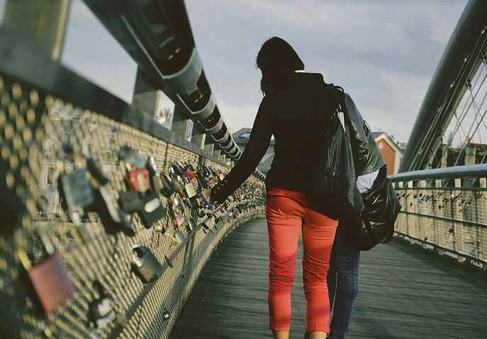 Woman walking alone on a pedestrian bridge while travelling solo after 40