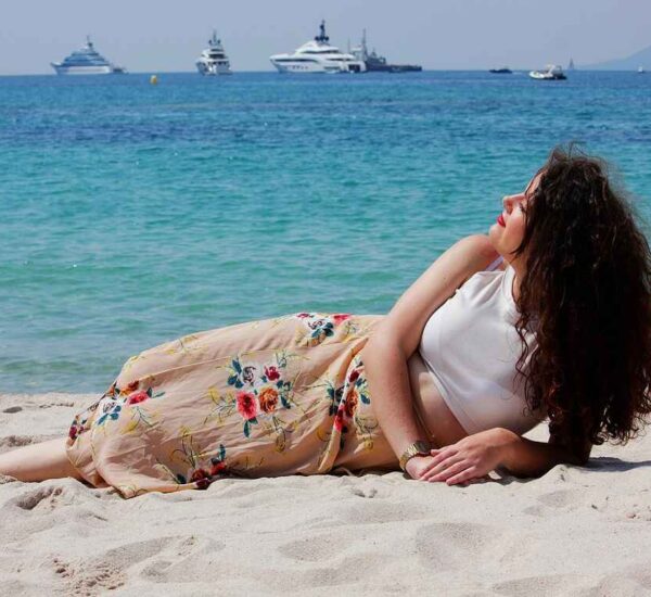 Woman relaxing alone on a beach at a calm solo travel destination after 40