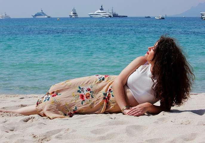 Woman relaxing on a sunny beach, enjoying a peaceful solo Valentine’s Day self-care trip