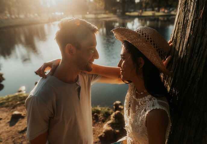 Couple standing by a calm lakeside at sunset during a romantic wellness escape