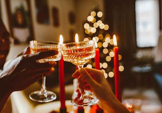 Couple toasting drinks by candlelight in a cozy, intimate setting