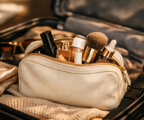 Cinematic hero shot of an open carry‑on with a beauty pouch and essentials peeking out.